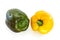 Two bell peppers, green and yellow, laying on a flat surface, isolated on white background with a clipping path