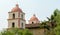 Two bell towers at the historic Santa Barbara mission amid lush trees