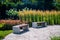 Two benches in a beautiful place in the city park. There is no one, a variety of bright vegetation in the park. A cozy place in