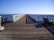 Two benches overlook the ocean on California pier