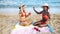 Two best multiracial friends sitting on summer beach