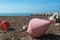 Two big buoys on the beach, azure sea and the rocky beach