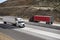 Two big rig semi trucks with trailers running on the highway in