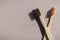 Two biodegradable bamboo toothbrushes on a beige background with contrasting shadows