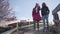 Two biracial people walking down the alley along wooden fence. Positive adult couple dating in the autumn park. Hippie