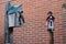 Two birdhouses with a brick wall background