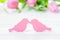 Two birds kissing on the pink tulips background