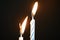 Two birthday candles against a dark background