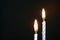 Two birthday candles against a dark background