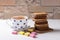 Two biscuits spread on top of chocolatiers with layers of chocolate and milk cream lying on a wooden plank.