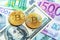 Two bitcoins on dollar and euro bills Investment, exchange rate, wealth, luxury, success, stock exchange - concept