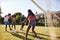 Two black adult couples playing football in garden