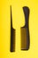 Two black combs on yellow background