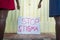 Two black female hands pointing to sign with text Stop Stigma``