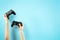 Two black joystick in hands isolated on pastel blue background