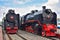Two black and red rare steam locomotives in a museum at the Riga station