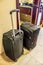 Two black suitcases with long handles in the hotel