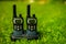 Two black walkie-talkies stand on a stand in the street,green grass in the background