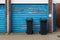 Two black wheelie bins outside the garage of a home awaiting collection