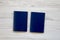 Two blank blue passports on white wooden