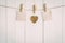 Two blank old paper and brown heart hanging. On white wooden