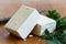 Two blocks of white tofu with fresh parsley and rustic knife on
