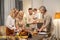 Two blond females and mature grey-haired man bending over served table