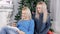 Two blond hair ladies watching into the tablet near the Christmas tree