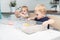 Two blonde boys twins play with kinetic sand at home. Creative play for kids