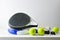 Two blue and black paddle rackets balls on white table