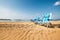 Two blue chaise-longues are on the sand ocean beach