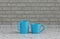 Two blue coffee cups side by side on a front view kitchen counter top with gray tiled brick wall, 3d Rendering, close-up view