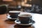 Two blue cups of hot coffee on vintage wooden table in cafe