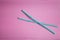 Two blue drinking straws on a pink background, without a plastic Cup