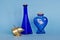 Two blue glass bottles with decorative brass object
