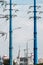 Two blue high voltage power line masts forming a natural framing against the backdrop of urban buildings. Wires and