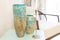 Two blue textured vases in the interior. They stand on a shelf in the living room, along with a hanging and candles