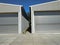 Two boarded metal hangar with closed rolling doors. Rolling shutter door of two large garages. Warehouse entrance with closed