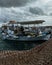 two boats docked in the water under cloudy skies and a wall