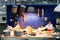 Two body paint gun sprayer red and blue installed on a workbench in a vehicle repair workshop next to another tool and  lighting