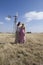 Two bohemian woman posing in field on farm