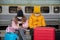 Two bored children in protective masks during the pandemic are waiting for a train on the platform.