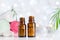 Two bottles with essential oil, towel and candles on white table with bokeh effect. Spa, aromatherapy, wellness, beauty theme.