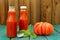 Two bottles of homemade ketchup with fresh green basil and red o