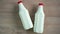 two bottles of milk lying on a wooden table