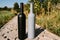 Two bottles stand on a rural road, private vineyards. natural drink. wine