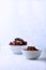 Two bowls with cacao beans and cacao powder isolated on white background