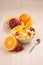 Two bowls with fruit salad on wooden table with half of orange