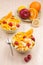 Two bowls with fruit salad on wooden table with spoon