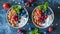 Two bowls of granola with fruits, Greek yogurt and berries top view